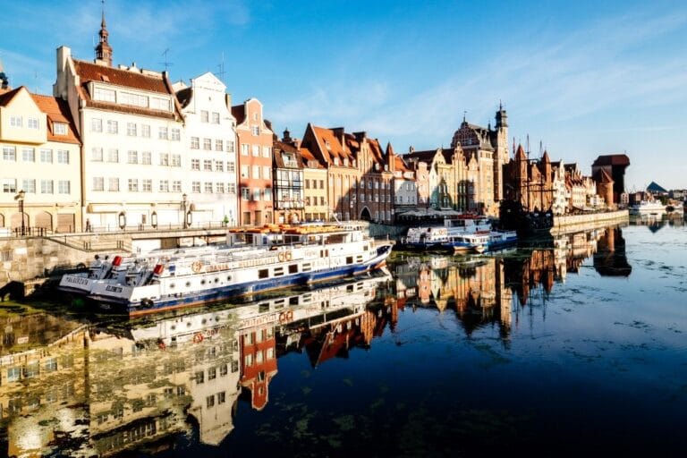 Boats on the river with historic buildings.