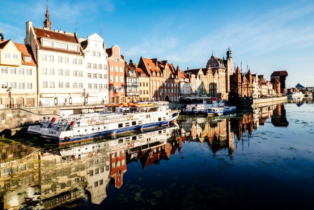 Boats on the river with historic buildings.